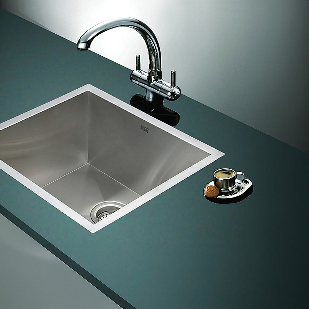 Stainless steel laundry sink with chrome faucet and countertop waste cover