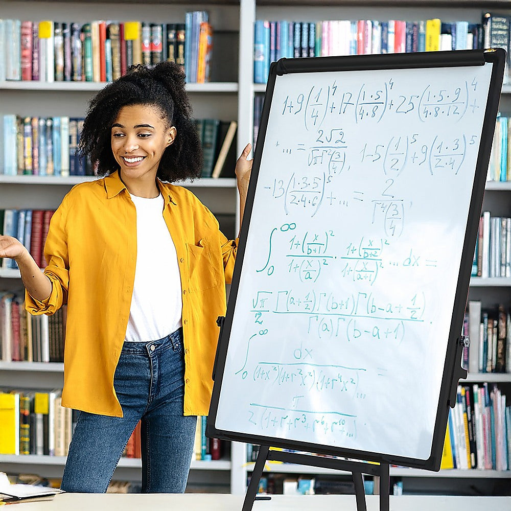 Dry erase whiteboard with black frame and handwritten math, on tripod stand.