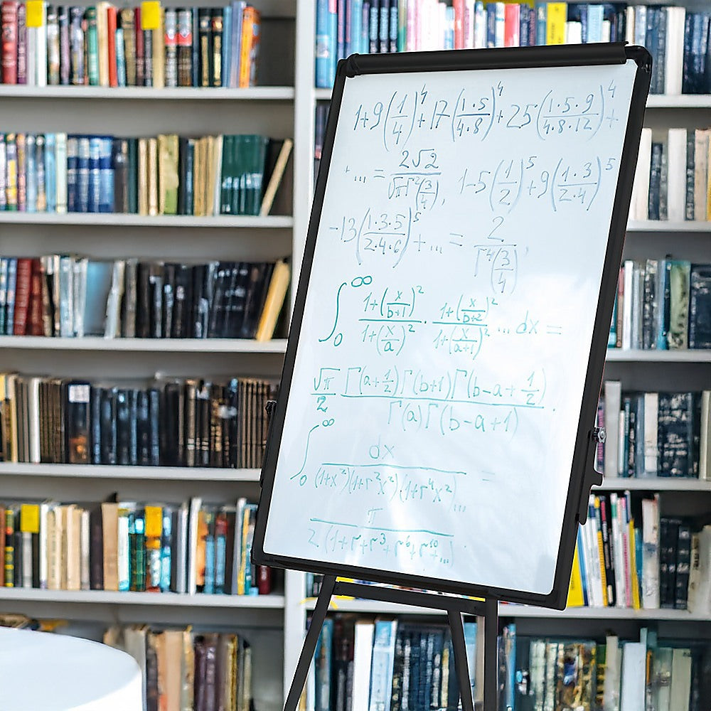 Dry erase whiteboard with black frame and visible writing, mounted on tripod stand.