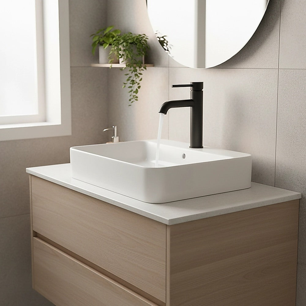 Matte black bathroom basin mixer tap faucet on a white vessel sink countertop
