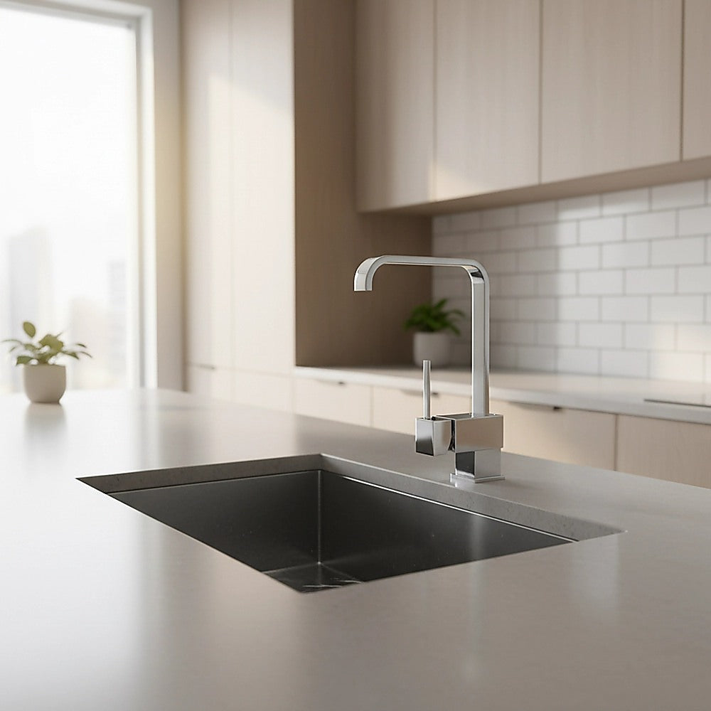 Chrome basin mixer tap over black kitchen sink with tall curved spout