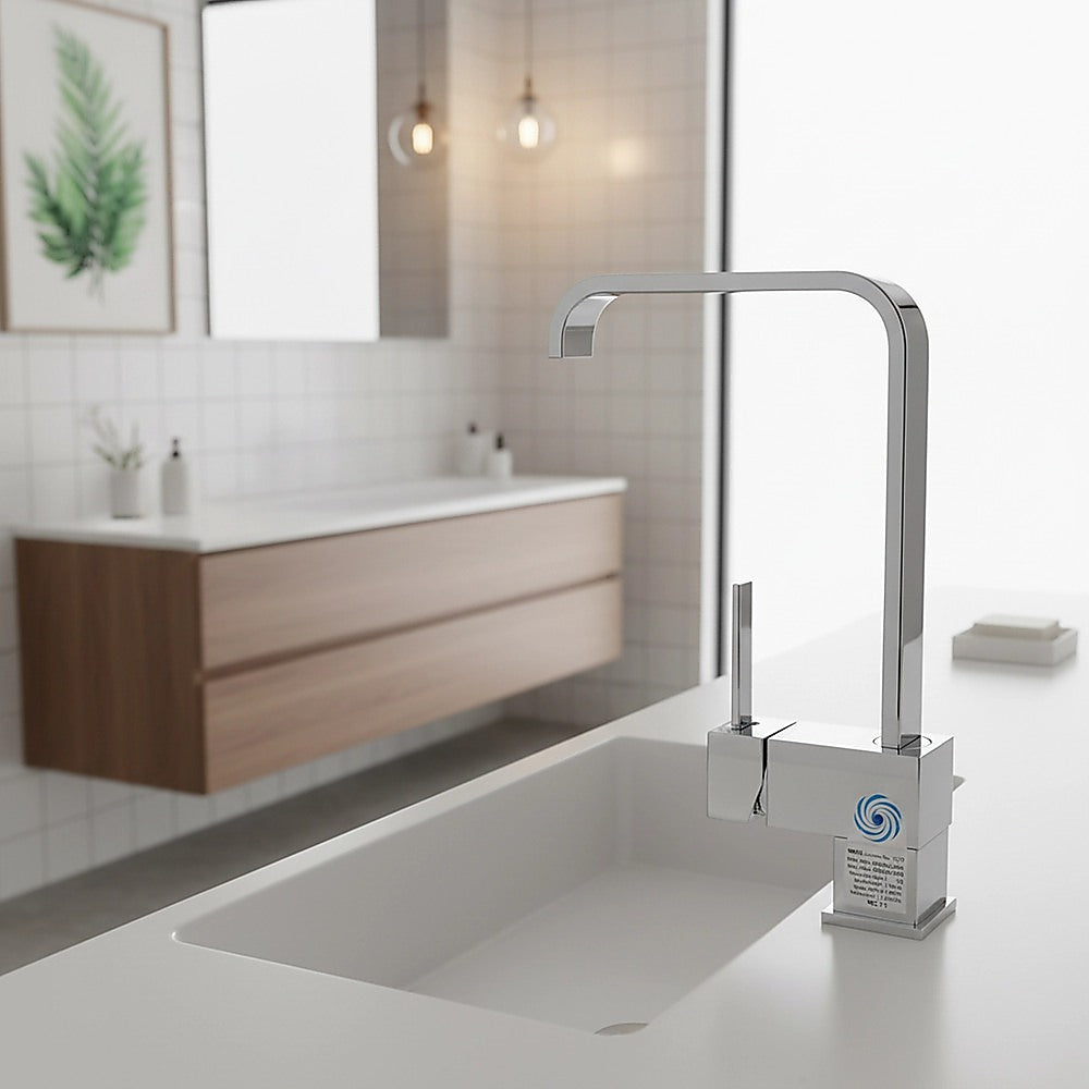 Chrome basin mixer tap on countertop with curved spout and two handles