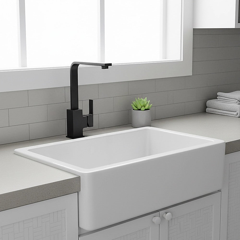 Matte black mixer tap faucet with tall spout over a white bathroom sink