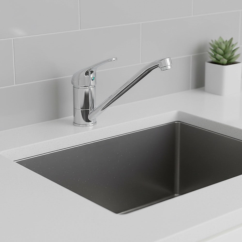 Chrome basin mixer tap on kitchen sink with curved spout and single lever