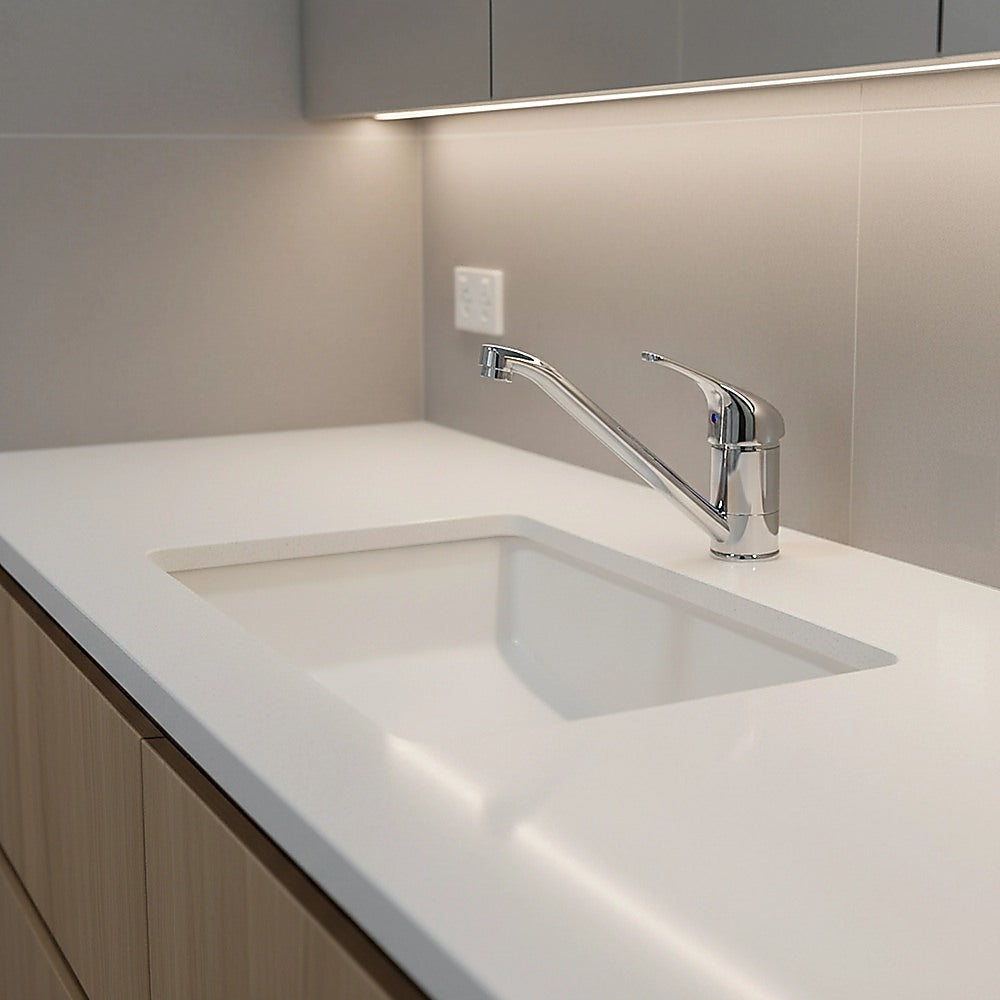 Chrome basin mixer tap faucet over white sink, tall arched spout and single handle