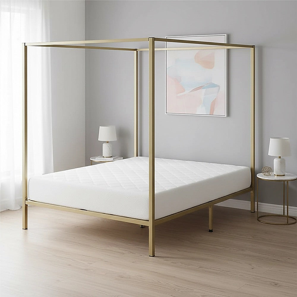 Four-poster king bed frame with gold metal canopy posts and open platform base