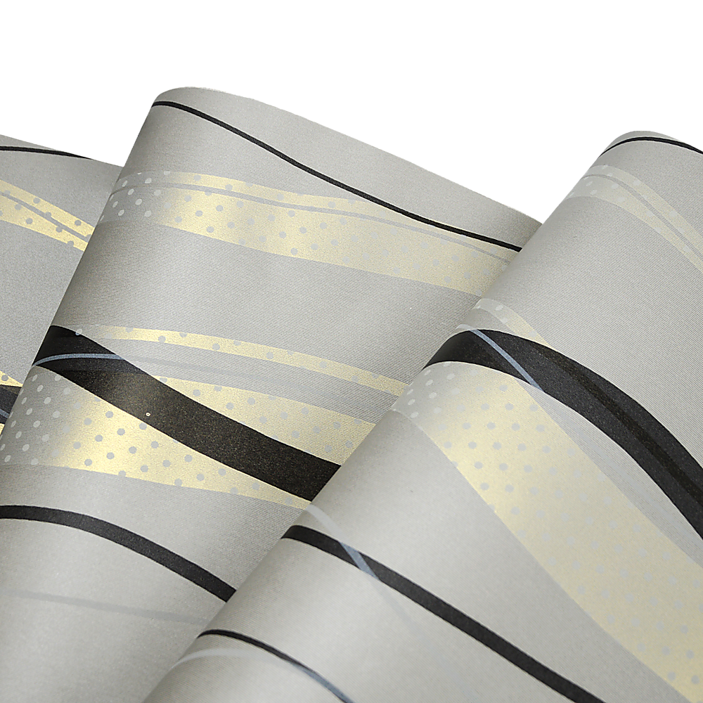 Wallpaper roll close-up: light gray base with black curved bands and gold dotted detail