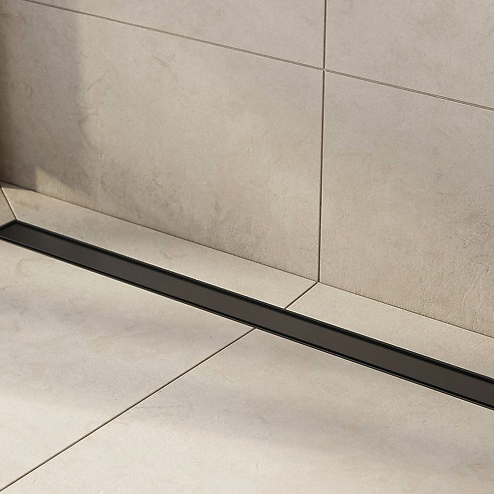 Black linear shower floor drain on tiled floor
