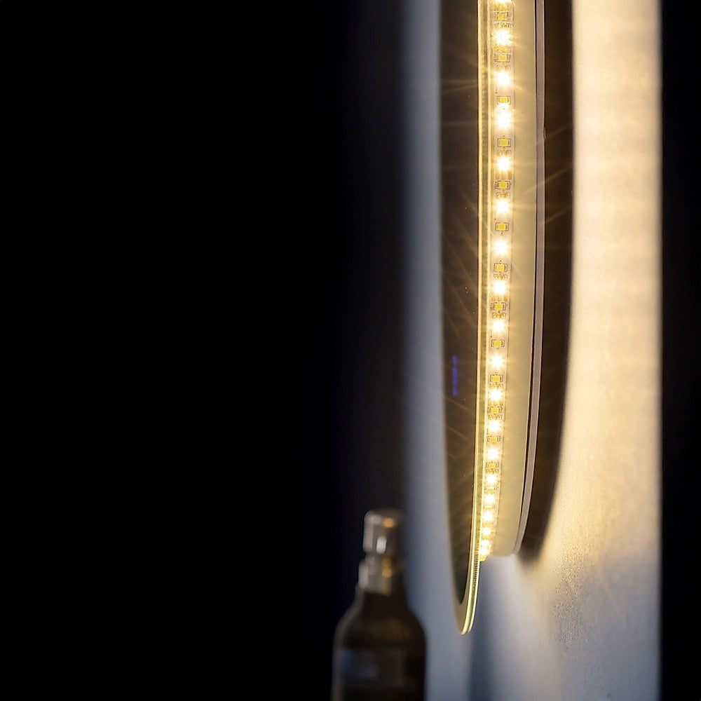 LED light strip along the edge of a round mirror frame, glowing white bulbs