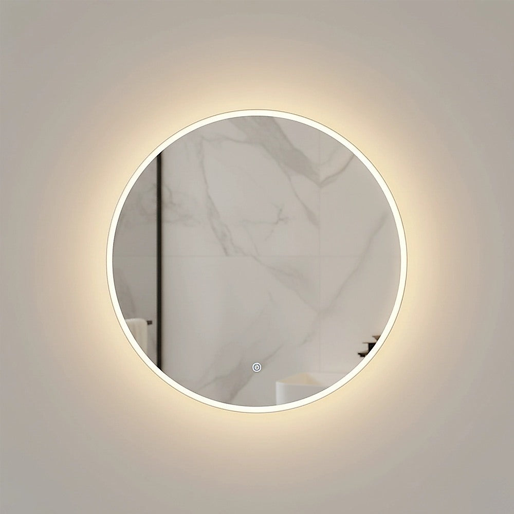Round LED wall mirror with silver rim and white light glow, reflecting marble
