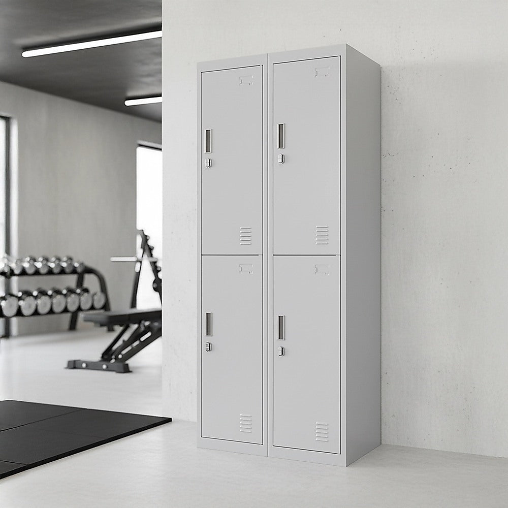 Four-door steel storage locker in a gym setting, light gray with four closed doors.