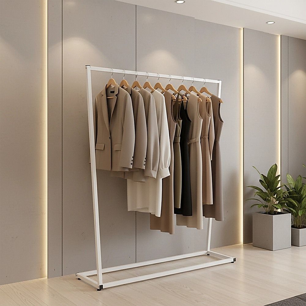 White garment rack holding coats and shirts on a hanging bar
