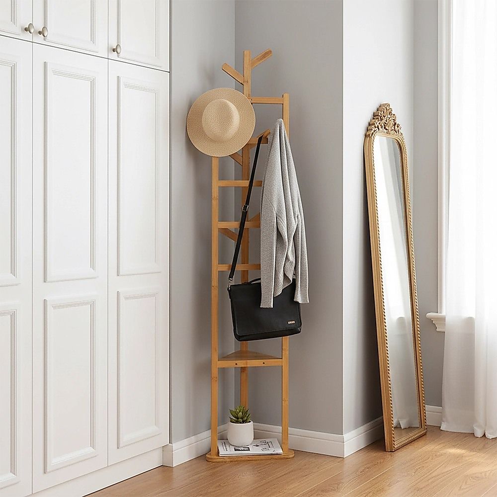 Wooden coat rack with hat on top and hanging coats with side bag