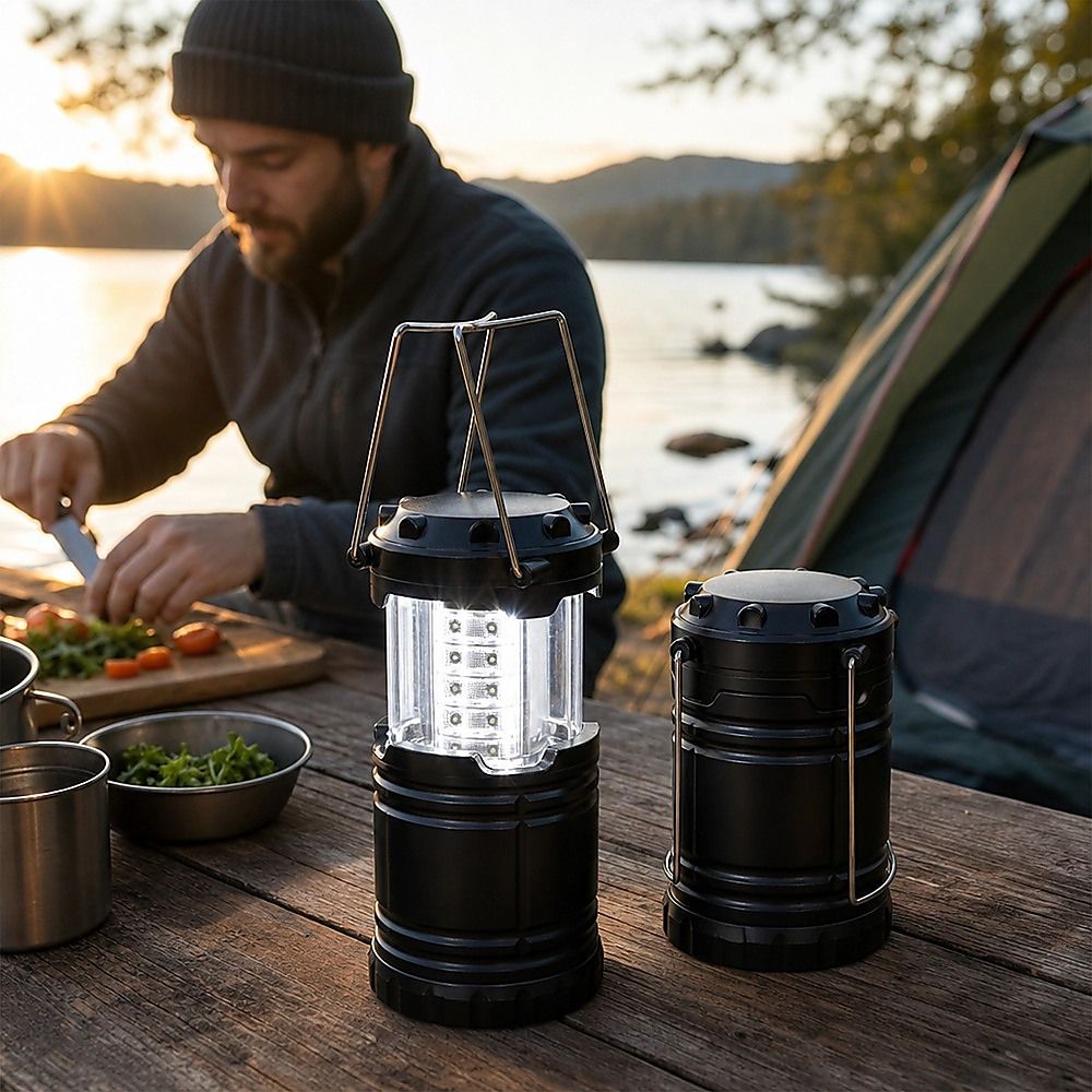 LED camping lantern on table, black body with clear side panels and metal handle bars