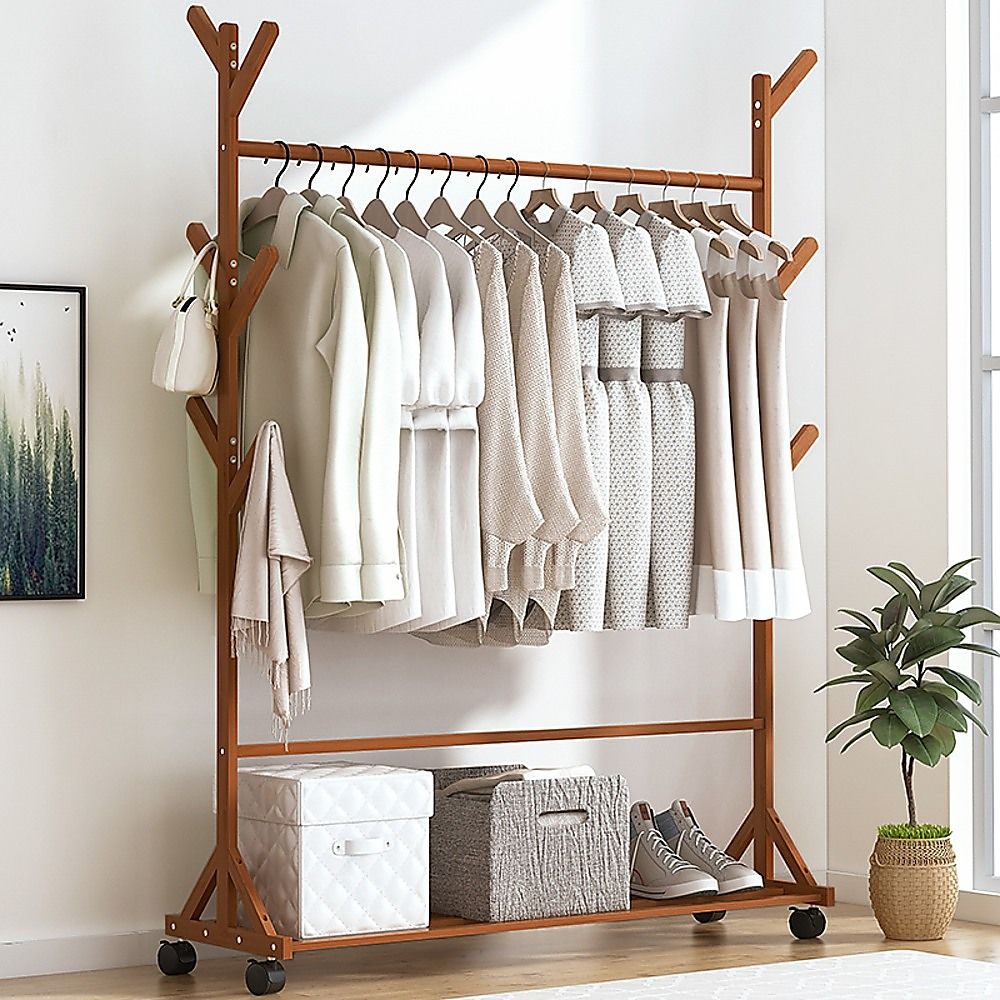 Bamboo clothes rack with hanging coats on top bar and storage on bottom shelf