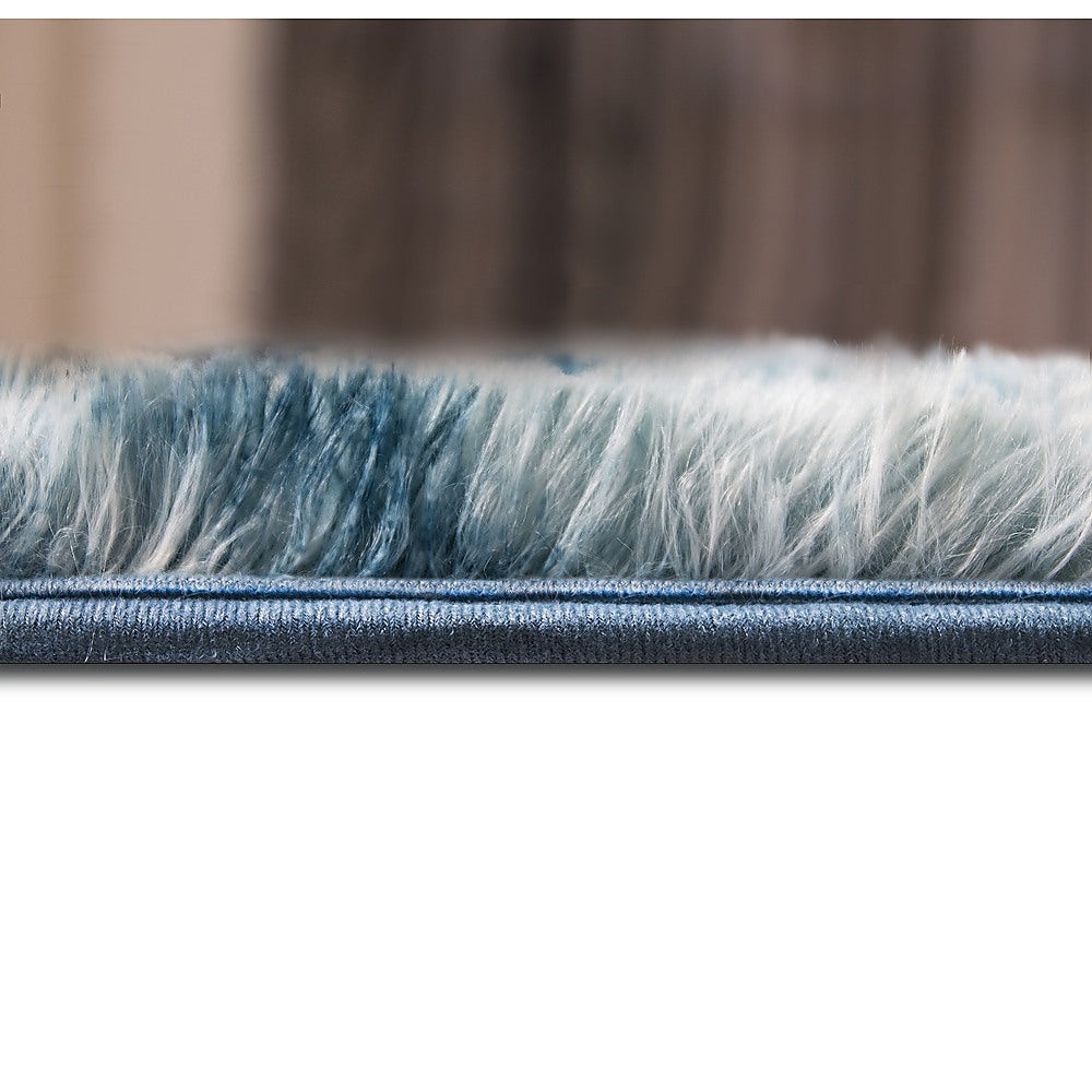 Blue shaggy rug edge with visible border seam and dense pile