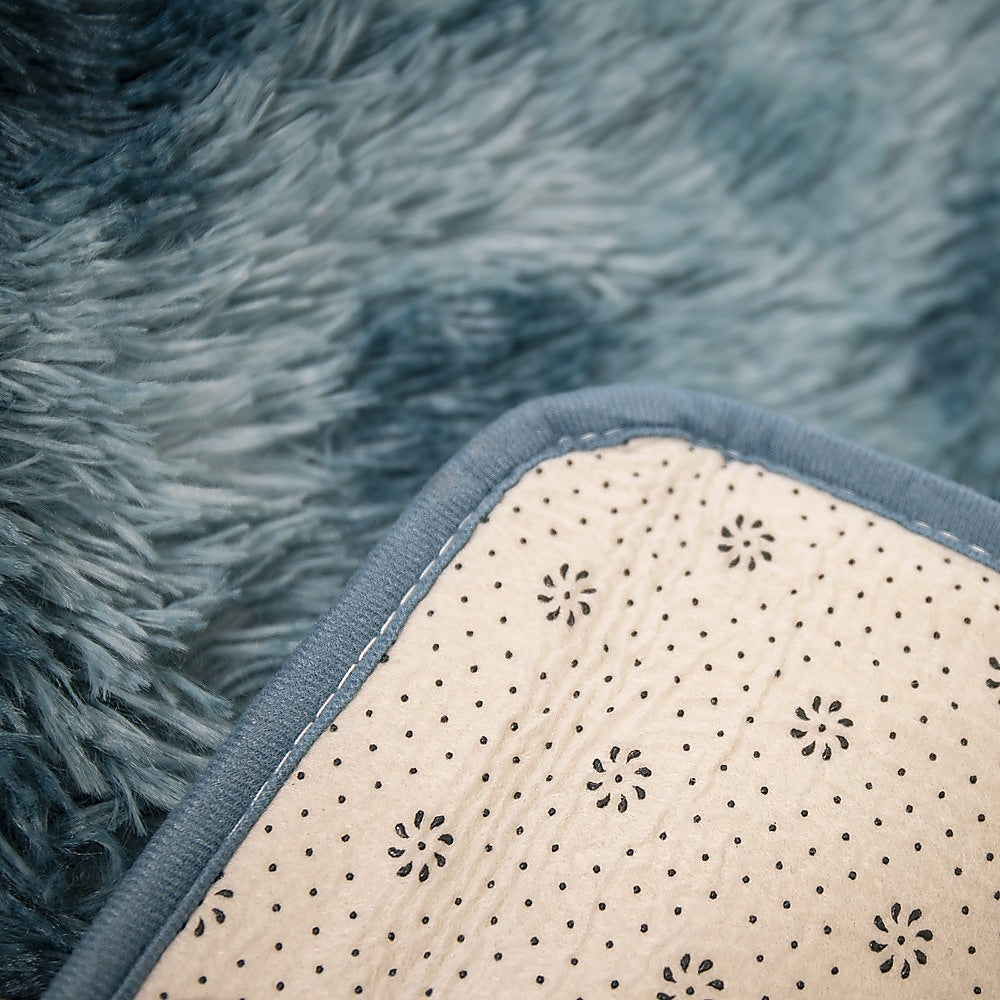 Blue shaggy rug corner showing cream underside with small floral dots