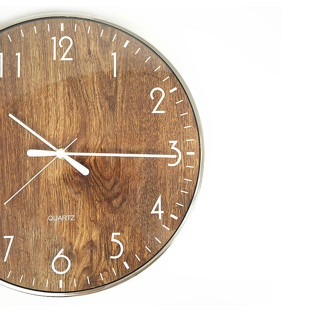 Close-up round wood-grain clock face with white numerals, markers, and hands