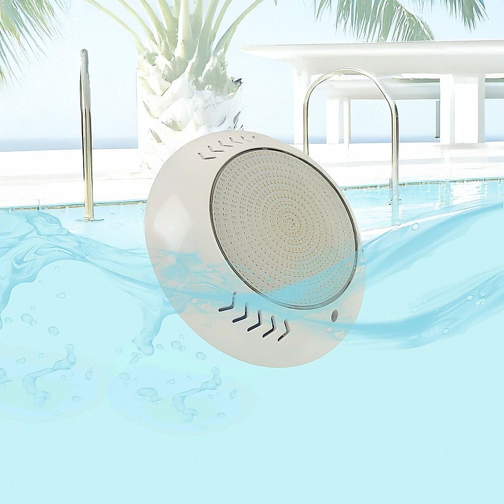 Round white LED pool light under water with circular lens visible
