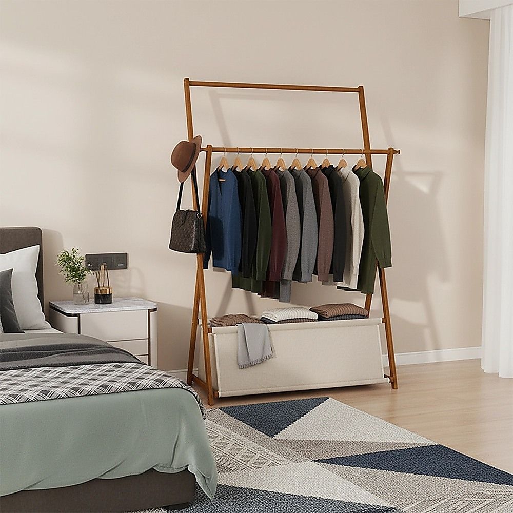 Dark wood clothes rail with hanging shirts and central storage shelf