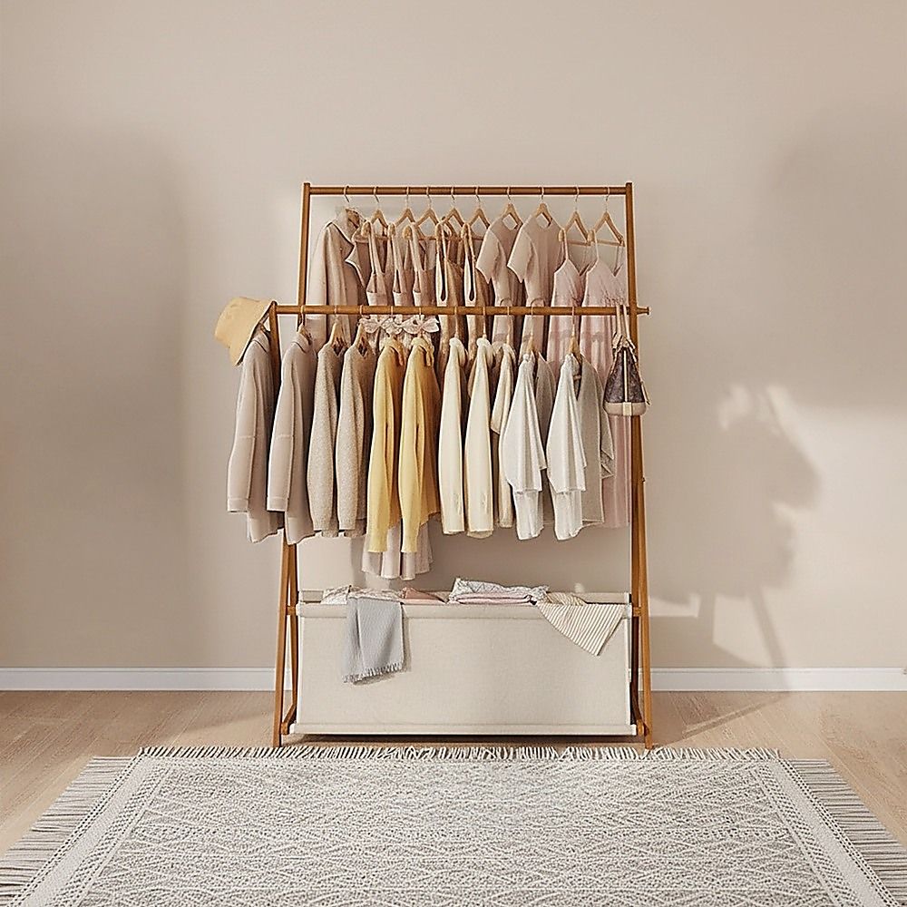 Dark wood garment rack with hanging tops and lower fabric storage drawers