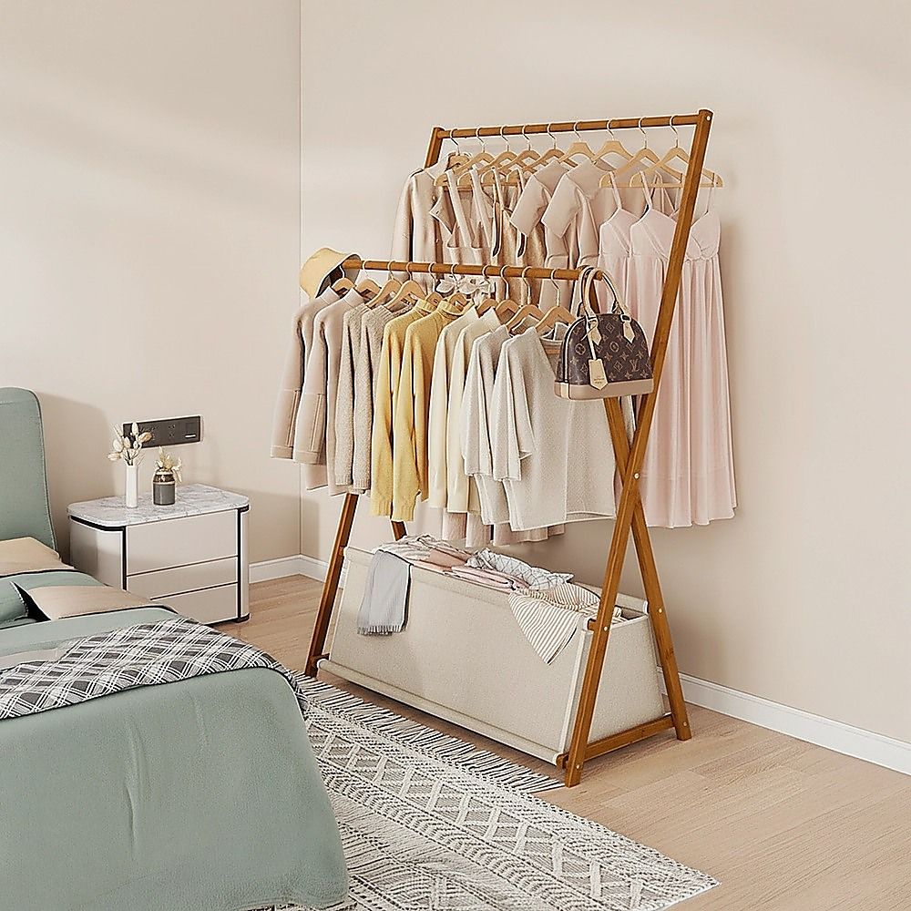 Dark wood garment rack with hanging shirts and lower storage shelf