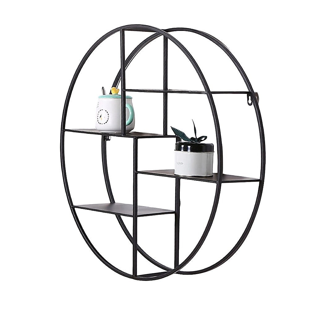 Black circular floating wall shelf with open compartments holding small decor items