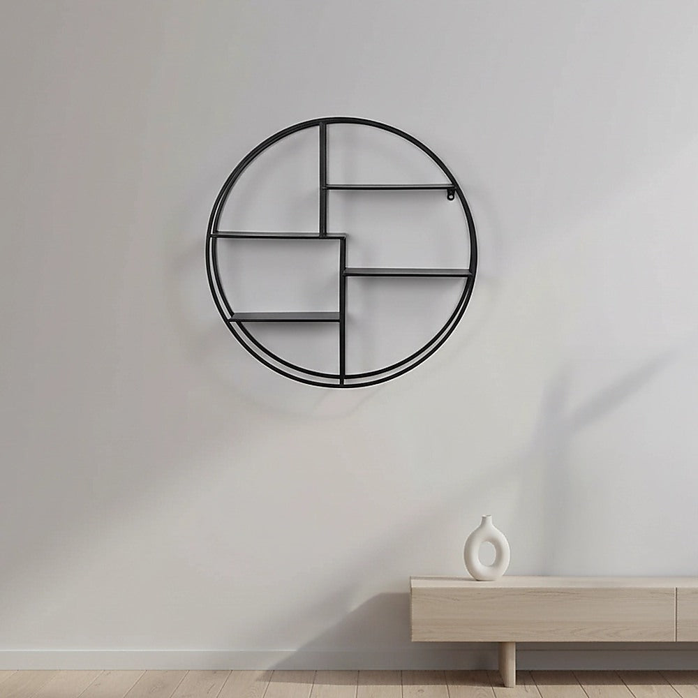 Black circular floating wall shelf mounted on wall with empty open shelves