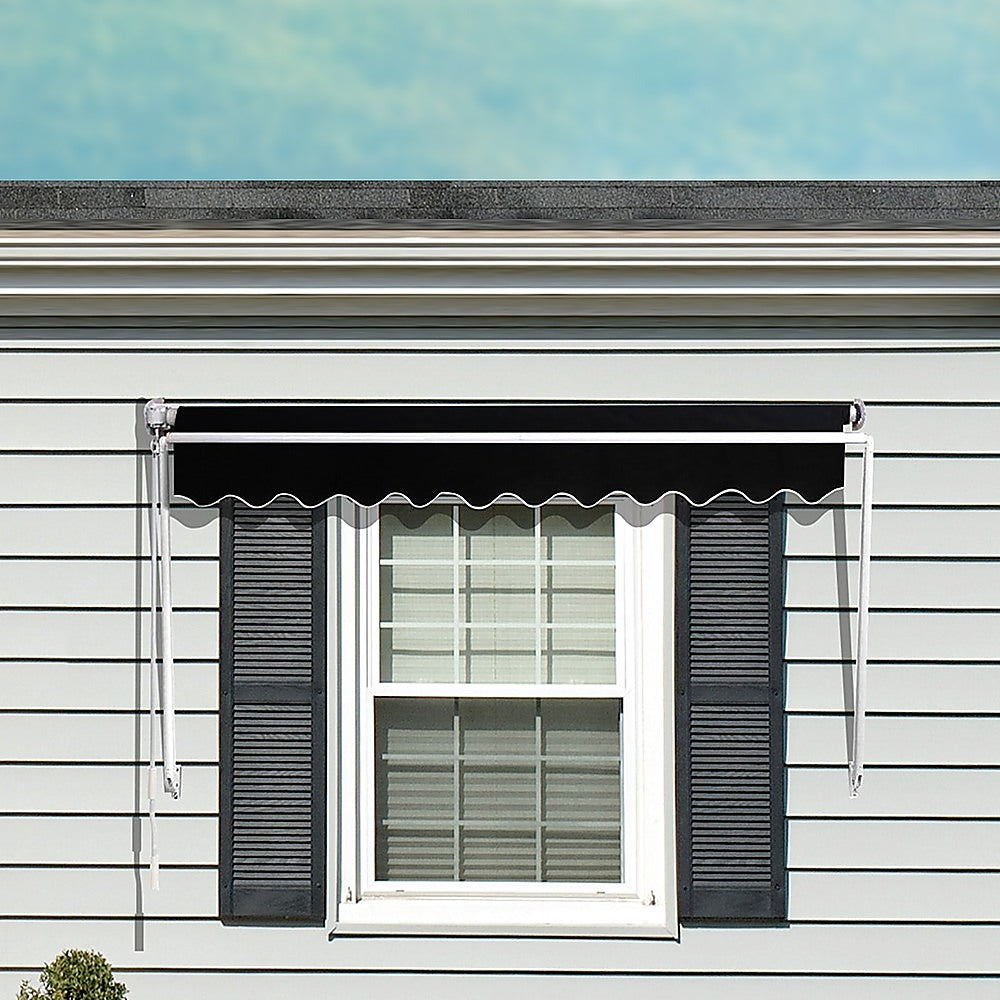 Black window awning with scalloped valance mounted above window