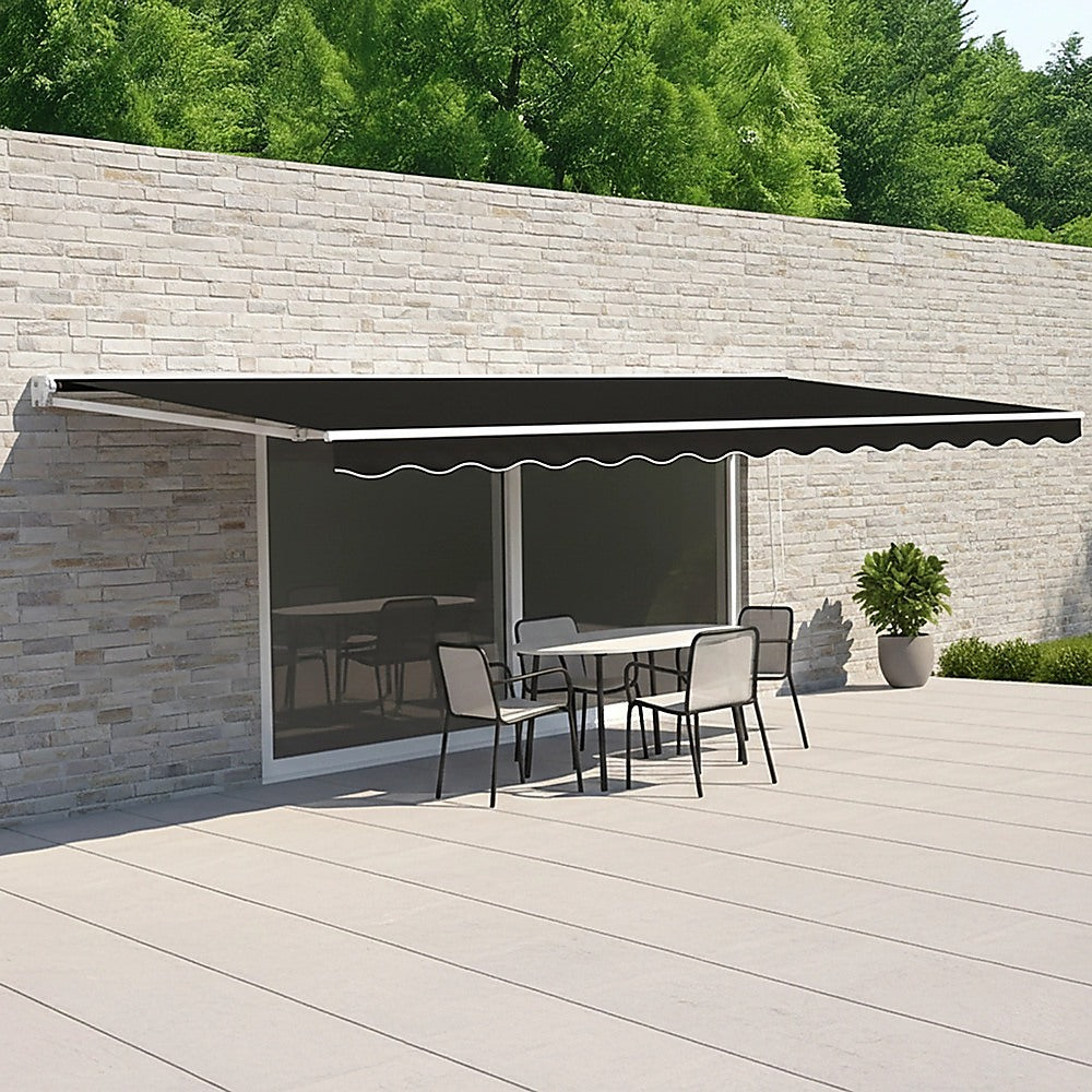 Motorized retractable awning with black canopy above exterior doorway