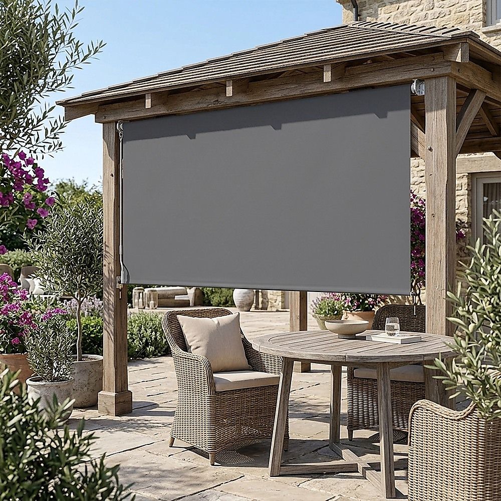 Retractable roll-down patio screen with dark gray fabric mounted under a wooden frame