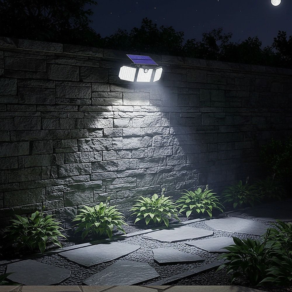 Solar LED wall security light casting a bright beam on an outdoor stone wall at night