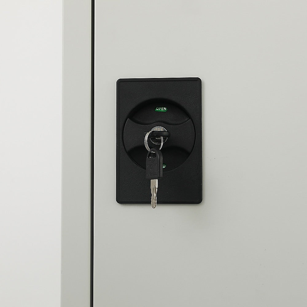 Single-door cabinet lock with keys and black handle plate on light gray metal door