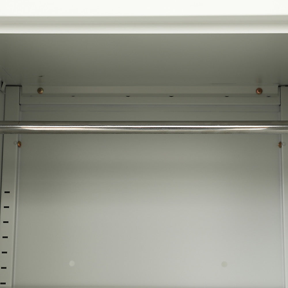 Interior top of tall metal cabinet with overhead rail and mounting screws