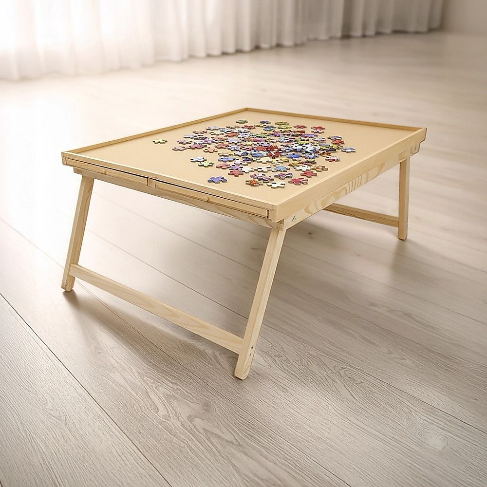 Wooden puzzle table with folding legs displaying a completed jigsaw on top
