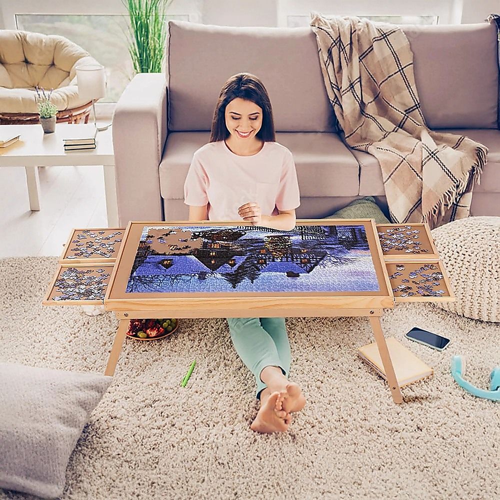 Wooden puzzle table on the floor with a large assembled jigsaw grid