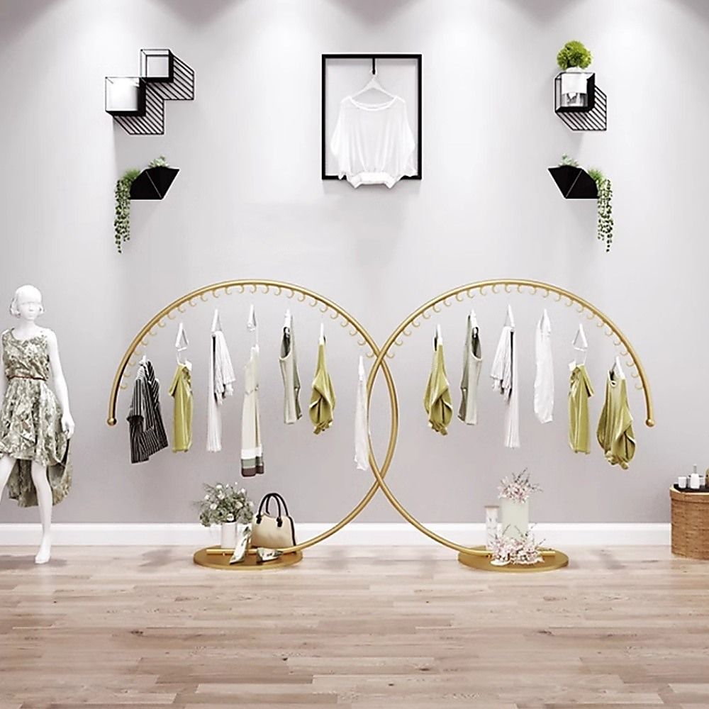 Double curved floor clothes hanger rack with gold rails and hanging tops