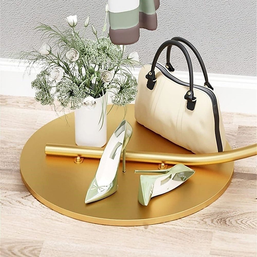 Curved floor clothes hanger rack with gold round base shelf and bar