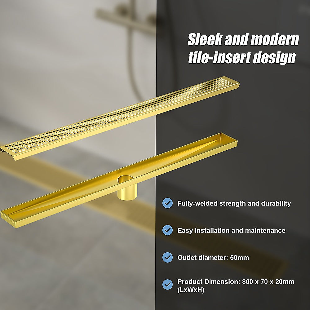 Brushed brass linear shower drain grate with central outlet and tiled inset design