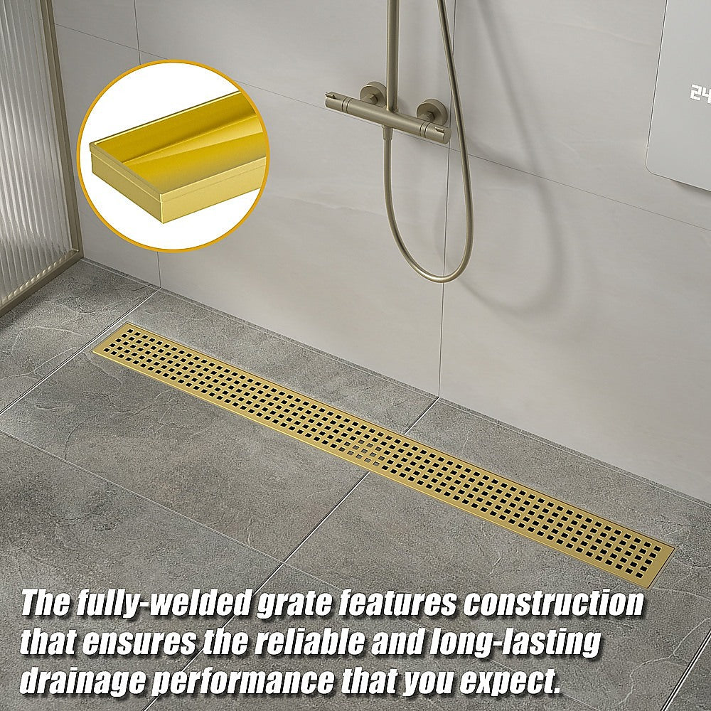 Brushed brass linear shower drain grate with central outlet, floor tile install