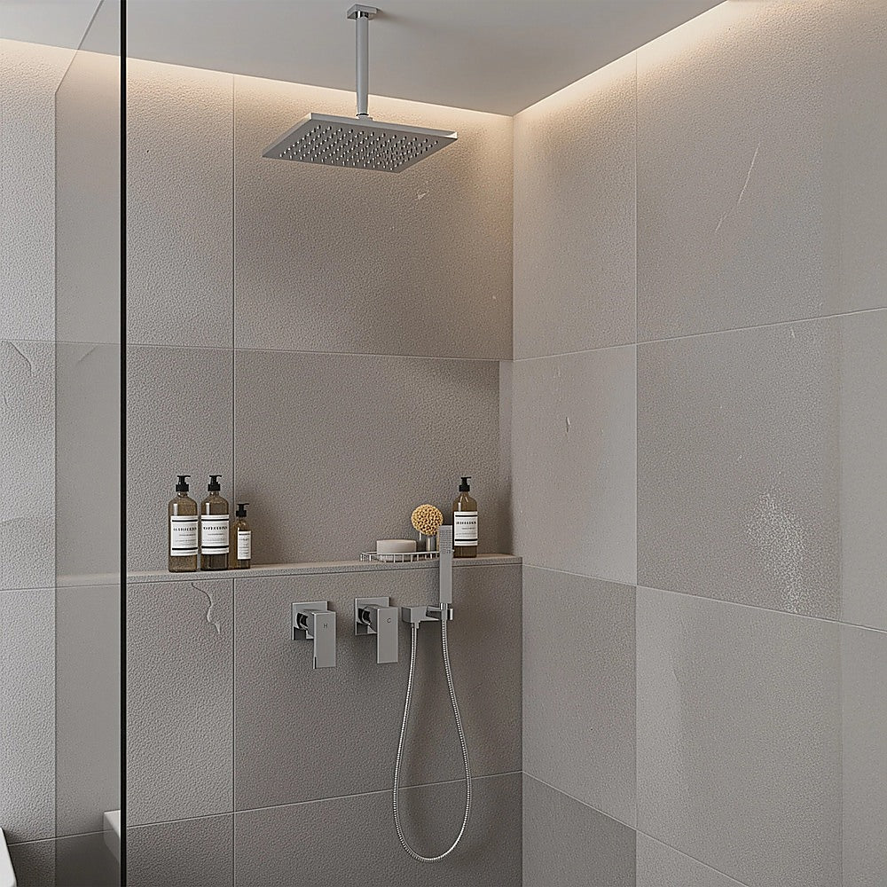 Chrome square shower/bath mixer mounted on tiled wall with shower head