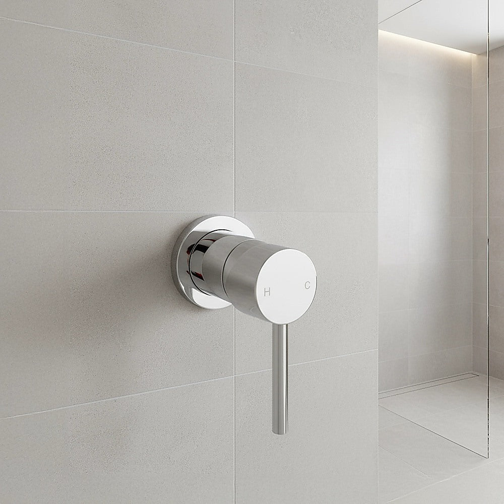 Round shower bath mixer tap mounted on wall with chrome trim and spout