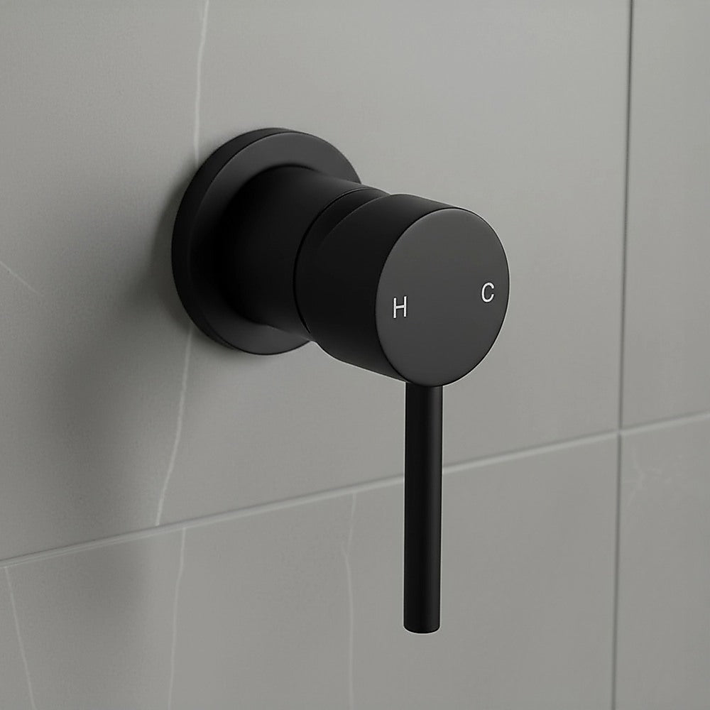 Matte black round mixer tap with H and C markings on shower wall