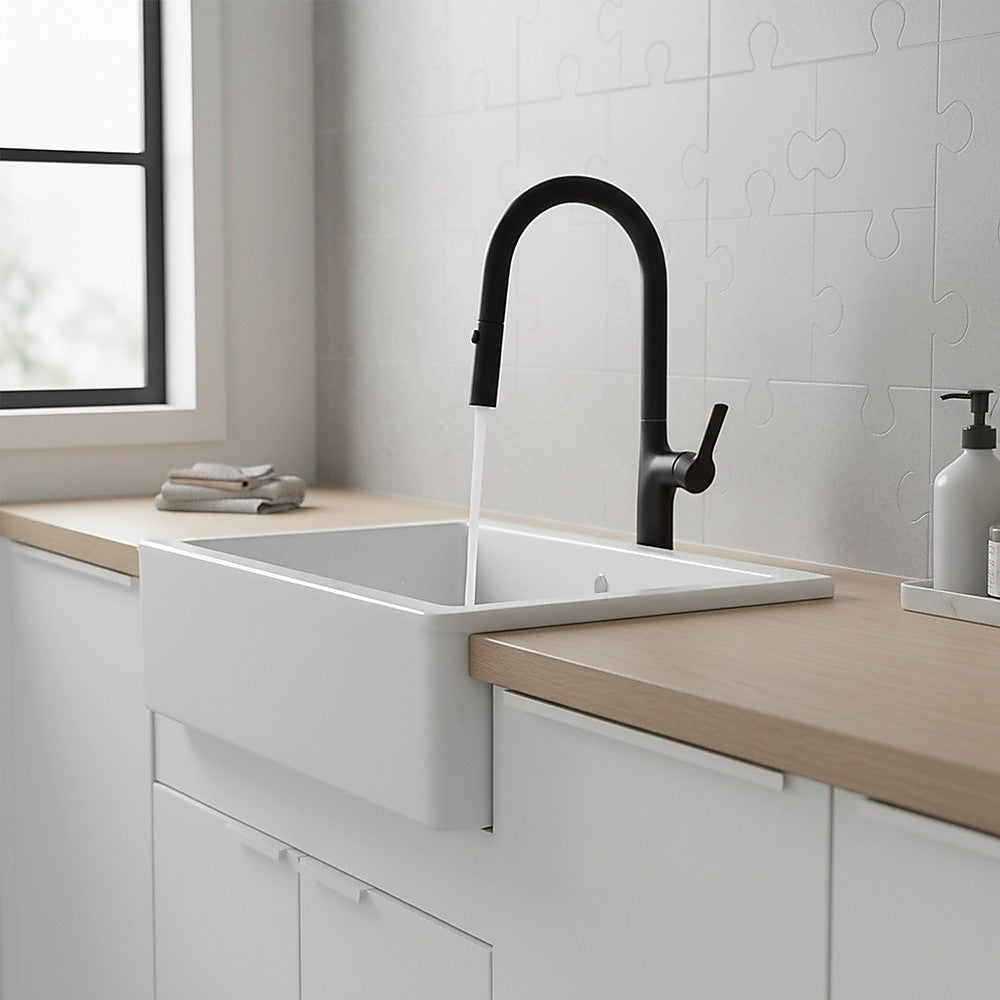 Black pull-out mixer tap faucet above white basin with tall curved spout