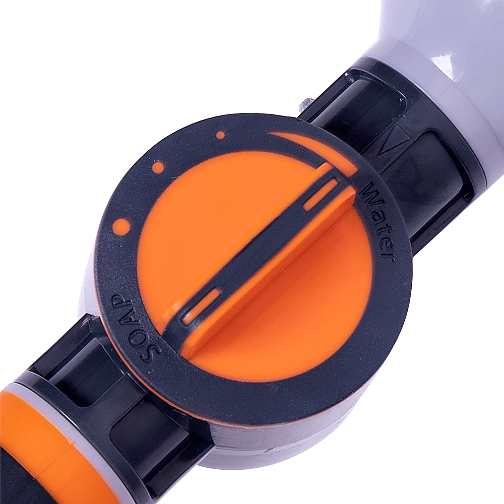 Close-up of garden hose nozzle sprayer orange selector dial on black housing