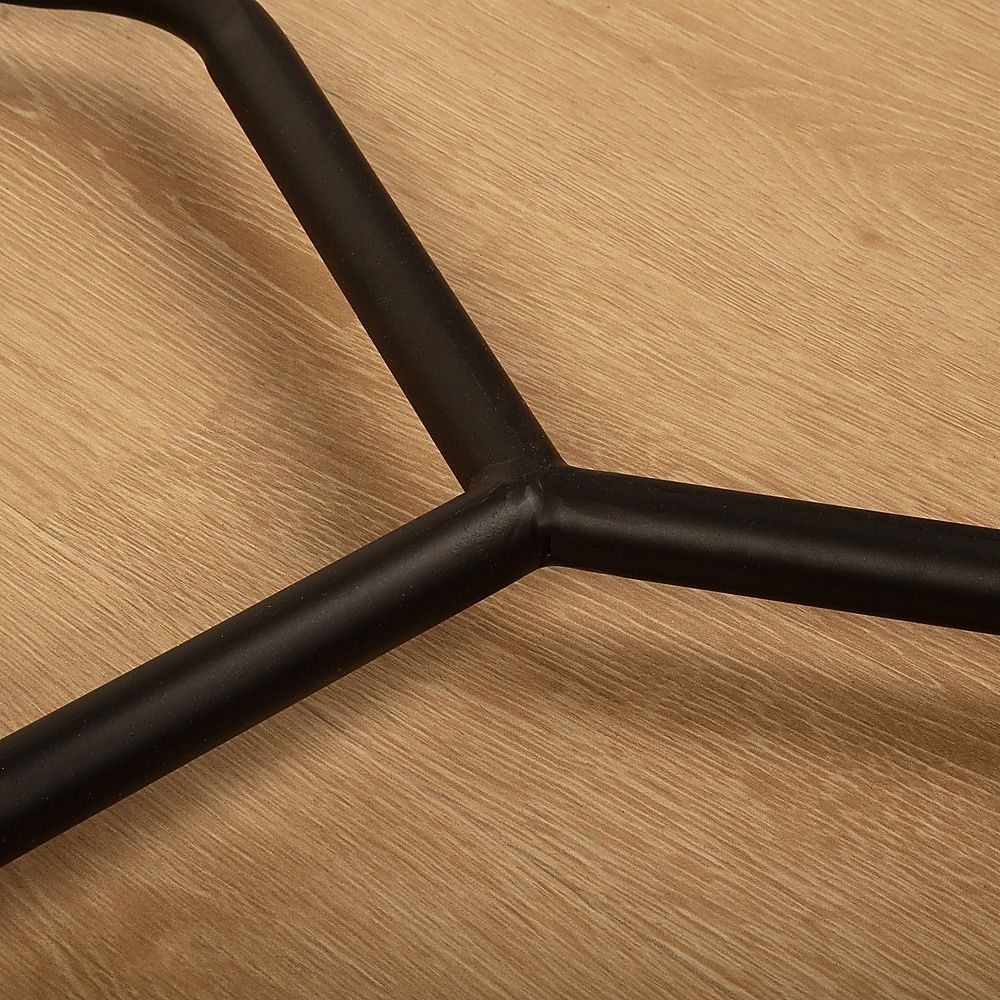 Close-up of black metal garment rack frame joint over a wood surface
