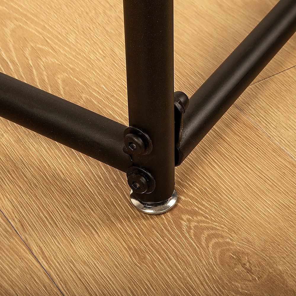 Close-up of black garment rack corner joint with metal foot on floor