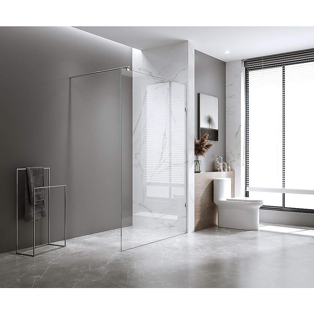 Tall clear glass shower panel with black metal uprights and base fixings