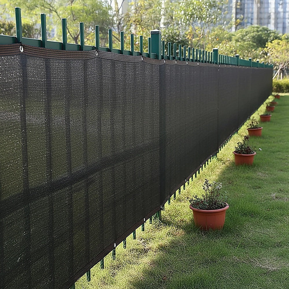 Black mesh privacy screen stretched along fence with evenly spaced grommets