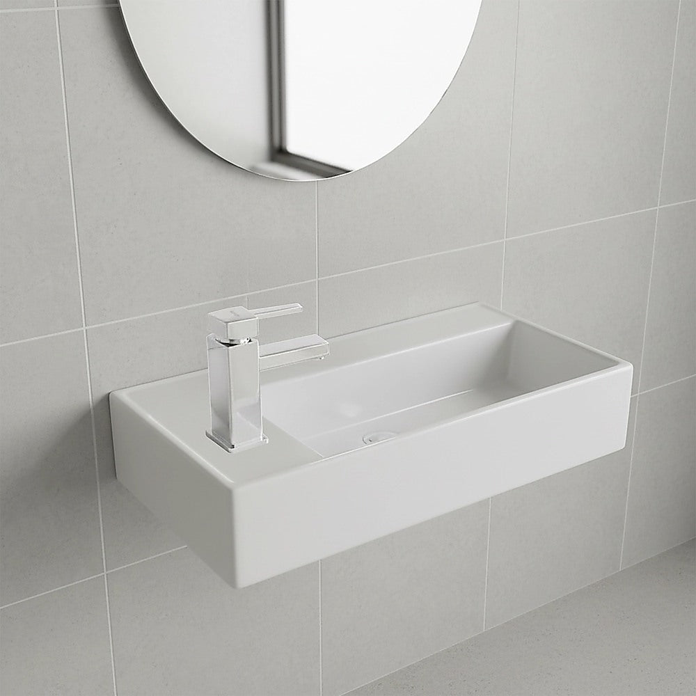 Wall-hung ceramic wash basin with mixer tap and drain, rectangular bowl in white